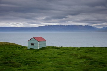Fototapeta na wymiar Icelandic landscape. A tin shack at the ocean. Peninsula Skagi, Skagafjördur.