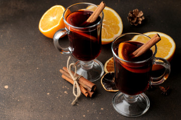 Hot mulled wine with cinnamon and orange in glass cups against a dark background. Christmas. new Year.