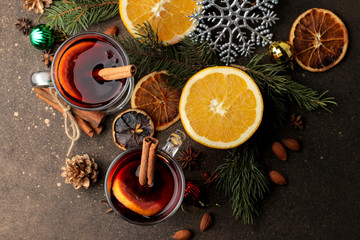 Hot mulled wine with cinnamon and orange in glass cups and Christmas decorations on a dark background. View from above. Christmas. new Year.
