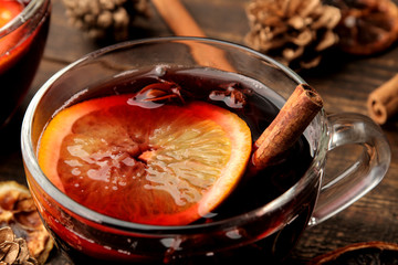 Hot mulled wine with cinnamon and orange in glass cups against a dark background. Christmas. new...