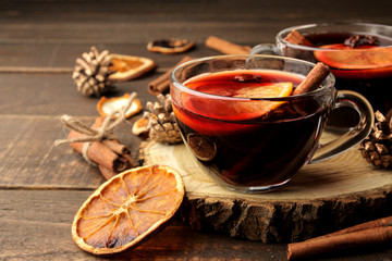 Hot mulled wine with cinnamon and orange in glass cups against a dark background. Christmas. new Year.