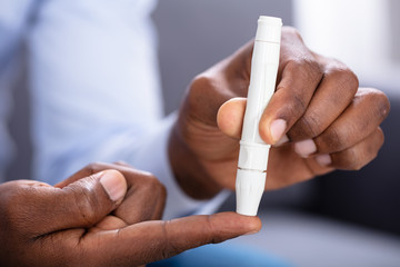 Man Checking Blood Sugar Level With Glucometer