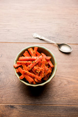 Carrot Pickle / Gajar ka Achar or Loncha in hindi. Served in a bowl over moody background. Selective focus