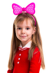 Happy little smiling blond girl in a red dress with a pink band bow on the white isolated background.