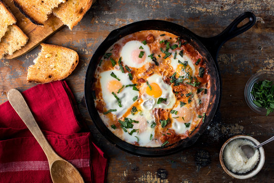 Overhead view of Shakshouka in frying pan on wooden table