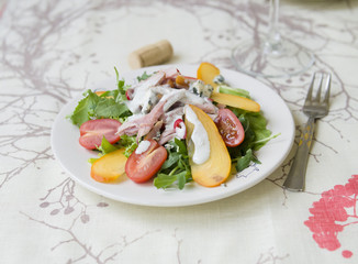 Salad with persimmon, smoked chicken, cherry tomatoes, Camembert cheese and blue cheese sauce. Festive dish . Christmas dinner. Selective focus, closeup, copy space