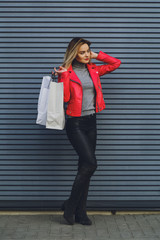 Young beautiful blonde girl with purchases, packages after shopping