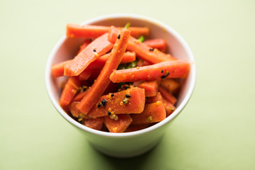 Carrot Pickle / Gajar ka Achar or Loncha in hindi. Served in a bowl over moody background. Selective focus
