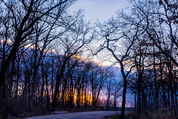 Naklejka na ściany i meble Sunset on the road through New Glarus Woods State Park in Wisconsin