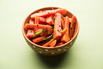 Carrot Pickle / Gajar ka Achar or Loncha in hindi. Served in a bowl over moody background. Selective focus