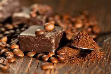 Chocolates and coffee seeds on wooden background