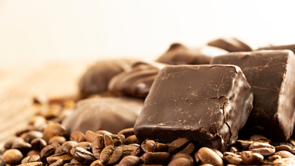 Chocolates and coffee seeds on wooden background