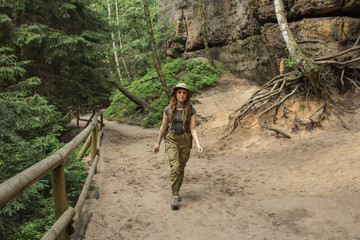 Young woman hiker travel alone in the forest and mountains with backpack	