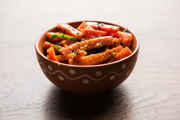 Carrot Pickle / Gajar ka Achar or Loncha in hindi. Served in a bowl over moody background. Selective focus