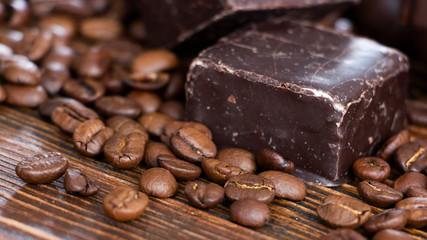 Chocolates and coffee seeds on wooden background