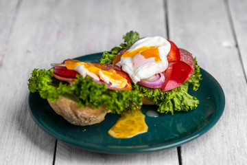 healthy and tasty sandwich with salami, peppers, purple onion, lettuce and poached egg