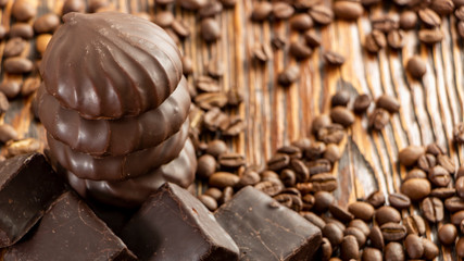 Chocolates and coffee seeds on wooden background