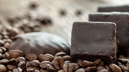 Chocolates and coffee seeds on wooden background