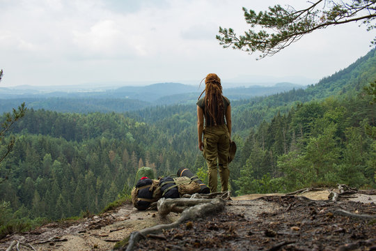 Young woman hiker travel alone in the forest and mountains with backpack	