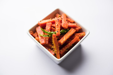 Carrot Pickle / Gajar ka Achar or Loncha in hindi. Served in a bowl over moody background. Selective focus