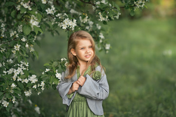 Fototapeta premium Portrait of a little girl in spring in flowering trees 1805.
