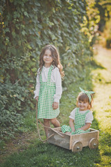 Two children play with a small cart 1875.