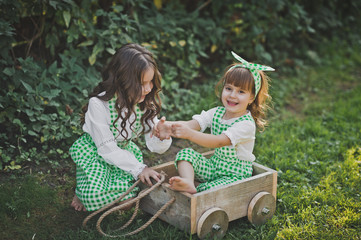 Two sisters play outside with a cart 1878.