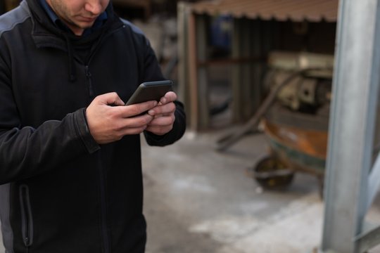 Man using mobile phone in foundry workshop