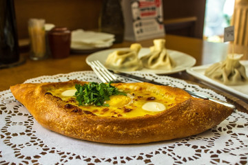 Khachapuri in Adjarian. Open pie with cheese and egg. Georgian cuisine.