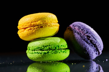 Cake macaron or macaroon on black background from, colorful almond cookies with reflection on glass