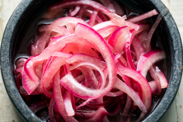 Close up of pickled red onion in bowl