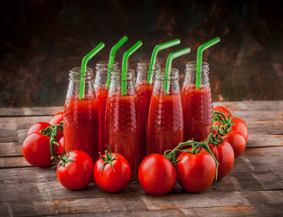 Fresh tomatoes and tomato juice colorful arrangement on wooden table