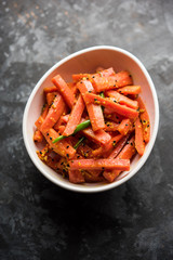 Carrot Pickle / Gajar ka Achar or Loncha in hindi. Served in a bowl over moody background. Selective focus