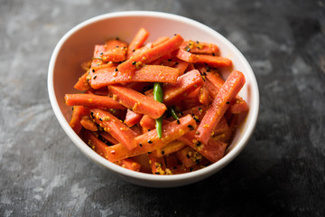 Carrot Pickle / Gajar ka Achar or Loncha in hindi. Served in a bowl over moody background. Selective focus