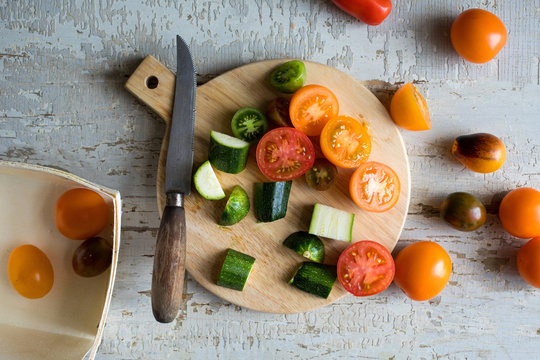Overhead view of tomato and zucchini on cutting board