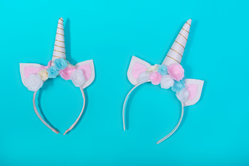 Unicorn headband with flowers and gold horn on blue background.