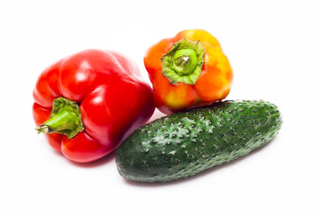Ripe peppers and cucumber on white background