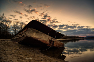 Rusty abandoned ship wreck in ship graveyard with dramatic effect