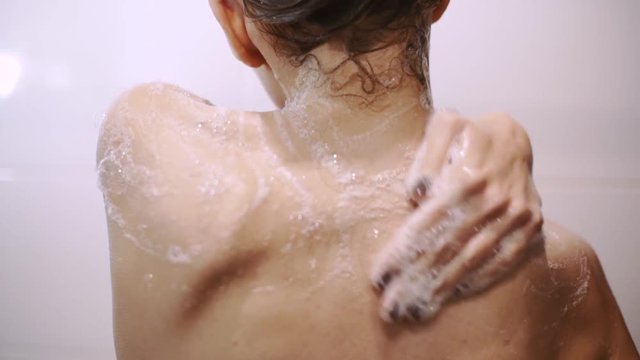 beautiful young red-haired woman bathes in the shower, washes her hair and her body