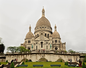 Fototapeta premium Vista desde un ángulo bajo de la fachada frontal de la Basílica del Sagrado Corazón de Montmartre en París, Francia. Día gris y nublado como fondo. 