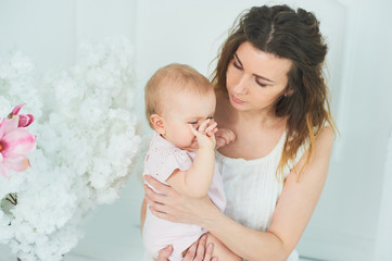 beautiful young mother with a baby in her arms is standing The concept of a happy family, motherhood