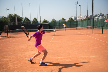 Young tennis player playing forehand