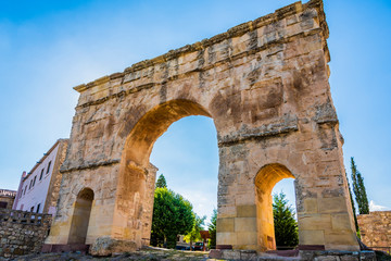 Close-up of Roman arch and back the village of Medinaceli. Soria Spain