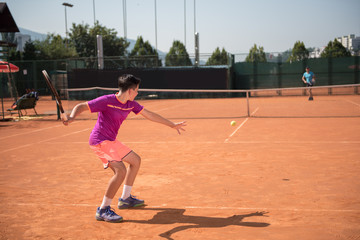Young tennis player playing forehand