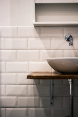bathroom sink with wooden table and white tiles