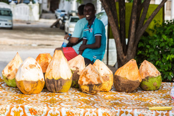 Street vendor of coconuts. Stone Town, old colonial center of Zanzibar City, Unguja island, Tanzania.
