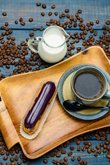 French coffee with cream and Eclair and coffee beans.