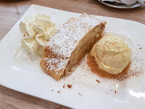 Teller mit Apfel Strudel Kuchen Sahne und Vanille Eis in einem Café