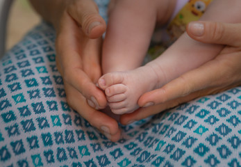 kleiner fuß eines Babys in der hand der Mutter