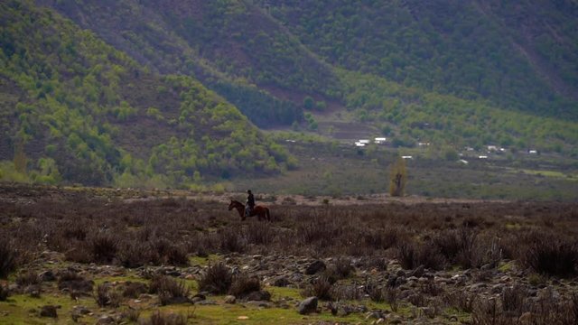 Beautiful landscape with mountains and a lone rider riding on the field. Trapa Trapa region Alto Biobio Chile. Flat plane